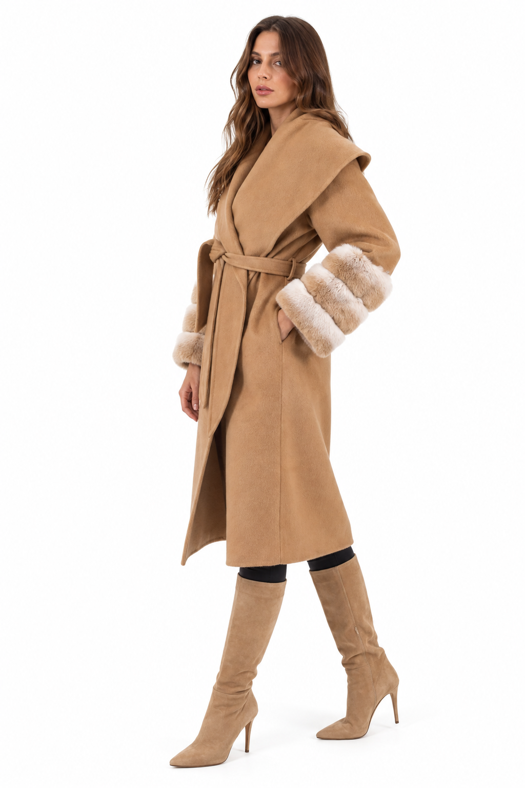 A woman models a mid-length camel-colored wrap coat with wide shawl-style lapels and fluffy cream rabbit-fur trimmed cuffs, paired with matching beige knee-high boots against a plain white background.