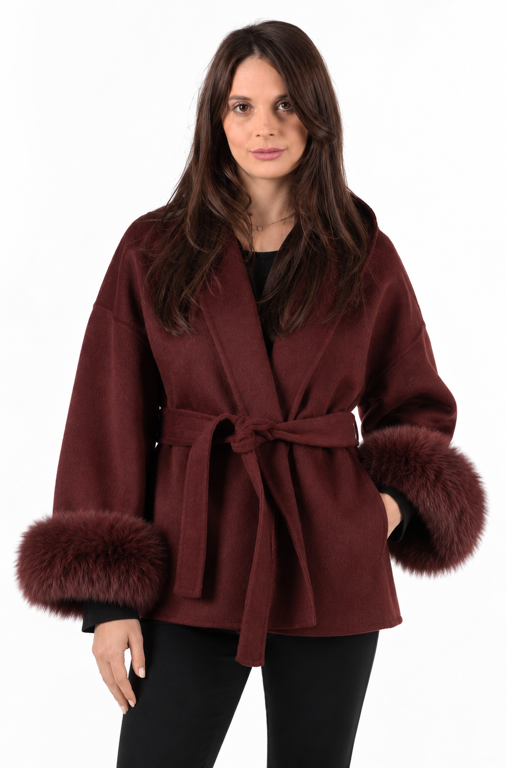 A brunette girl wearing a cashmere and wool coat in burgundy with detachable real fox fur sleeves.